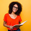 Young lady smiling and holding a book in her hand