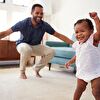 Father assisting baby girl learn walking