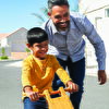 Father assisting son learning cycle