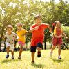 Children Competing in Running on Grass