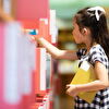 Girl Taking a Book From Library Shelf