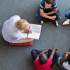 Teacher reading book loudly for students - landscape cut